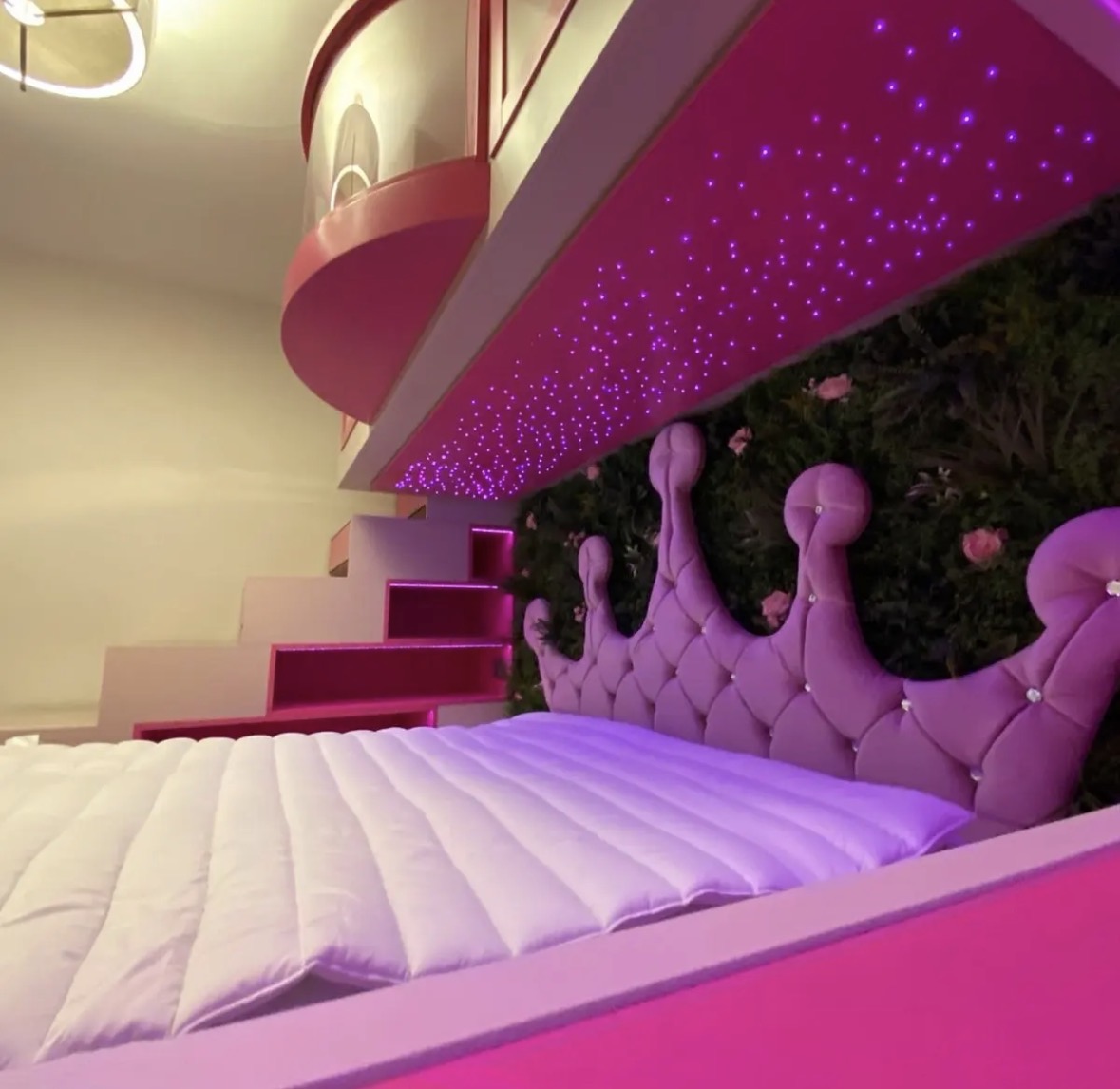 Detail of a bespoke children's bed with starlight LED ceiling panel, crown-shaped upholstered headboard and storage steps