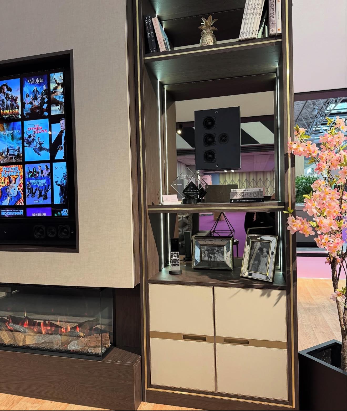 Bespoke media wall display shelving in dark stained oak with brass trim, LED lighting and a mirrored back panel
