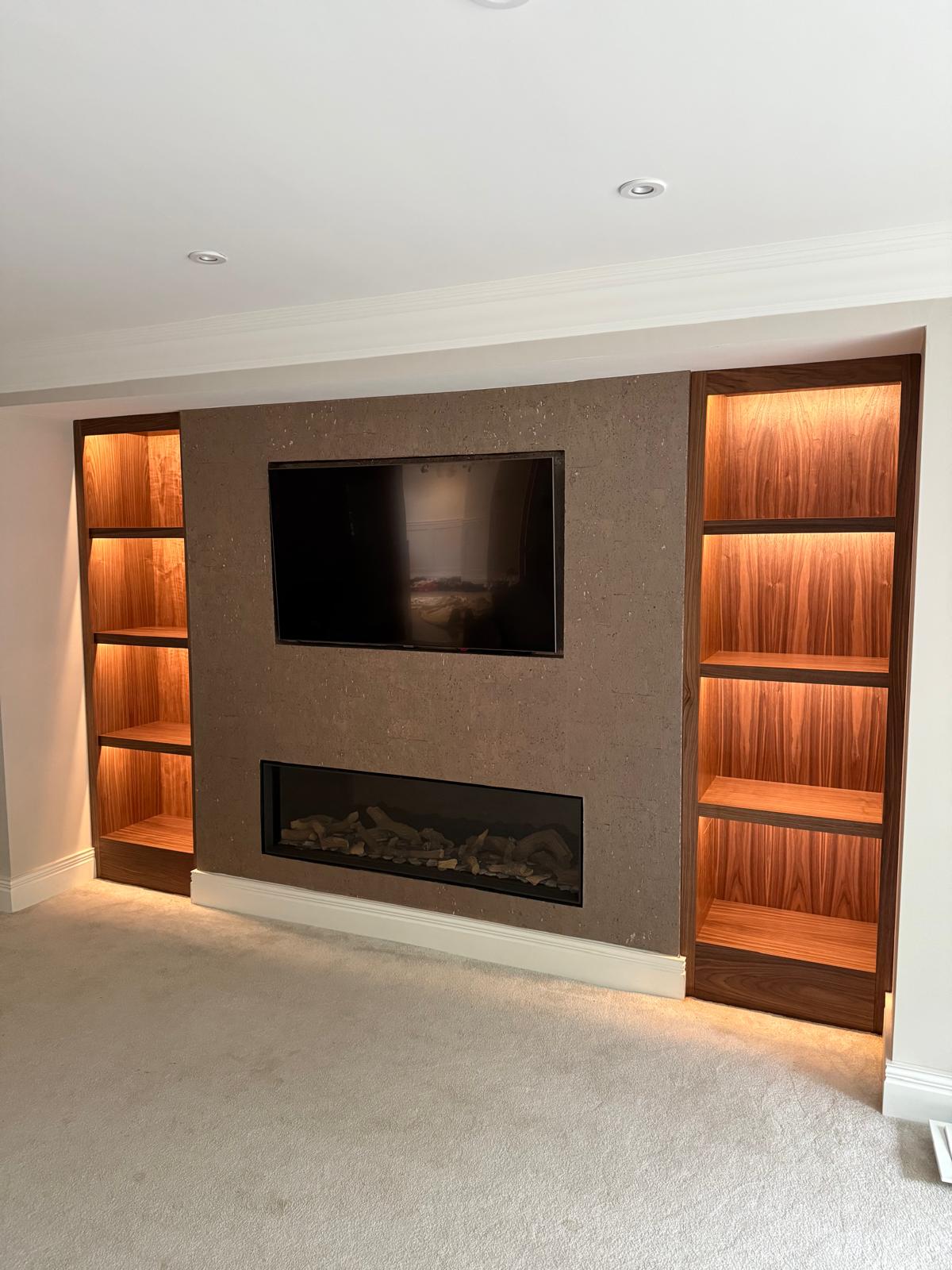 Media wall with a textured stone-effect centre panel, recessed television, long inset log-effect fire and LED-lit walnut shelving either side