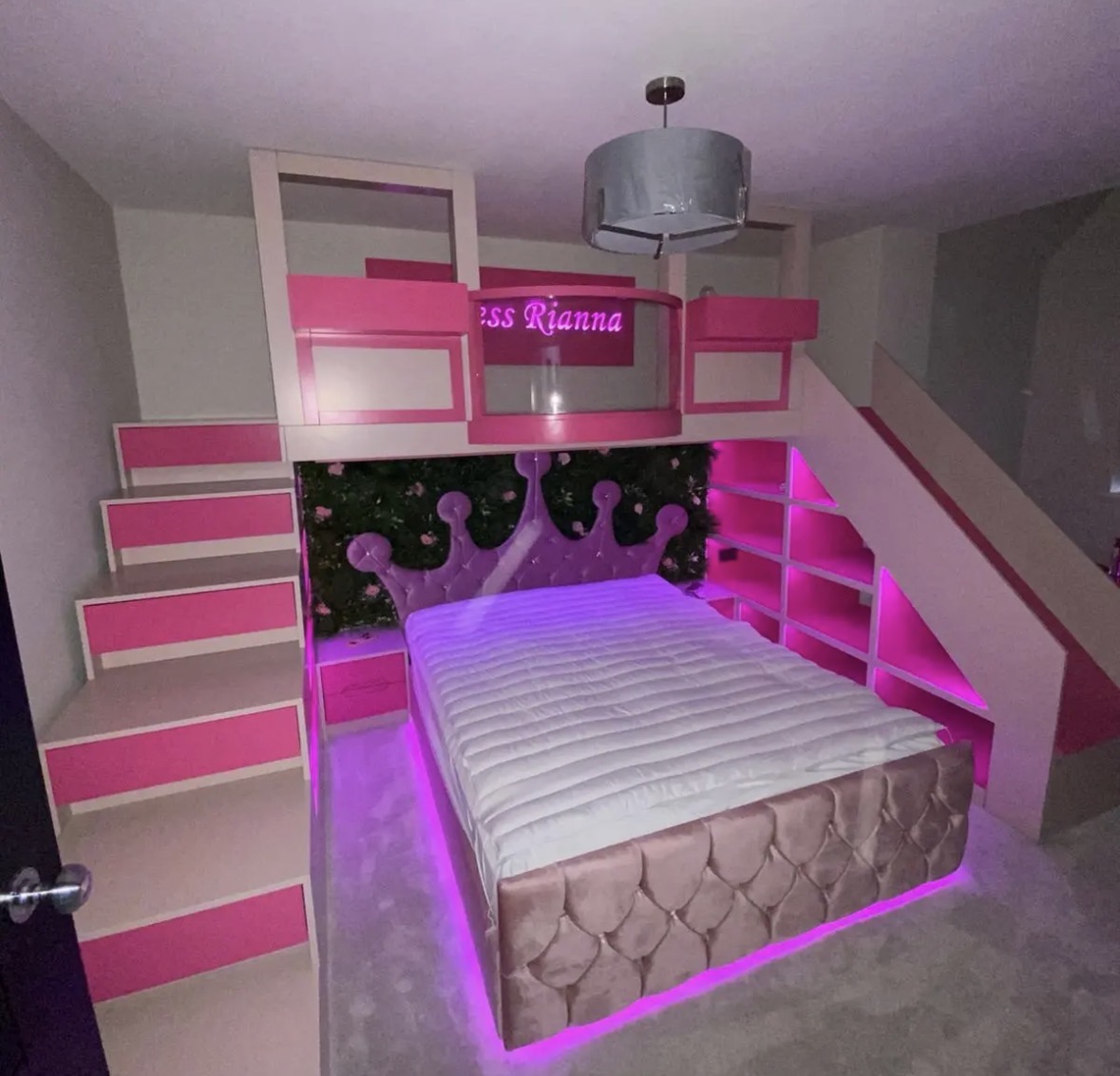 Bespoke children's bunk bed with a staircase of drawers, slide and colour-changing LED lighting in pink and white